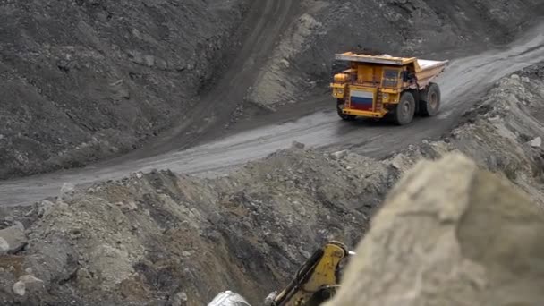 Verano, 2020 - Territorio Primorsky, Rusia - Arriba. Un Belaz amarillo está conduciendo a través de una cantera con un cuerpo cargado de tierra sobre el fondo de altos montones de tierra — Vídeo de stock