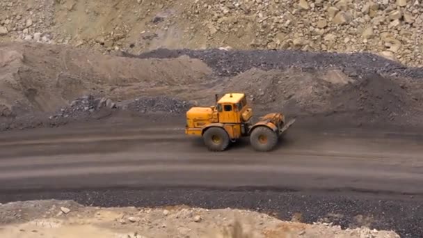 Verano, 2020 - Territorio Primorsky, Rusia - Arriba. Un Belaz amarillo está conduciendo a través de una cantera con un cuerpo cargado de tierra sobre el fondo de altos montones de tierra — Vídeos de Stock