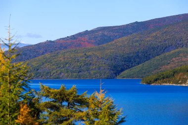 Rus tundrasında mavi bir nehrin arka planındaki yüksek dağlar