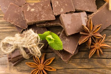 Çikolata, tarçın ve anasonu ahşap bir masa üzerinde parçalar. Kopya alanı