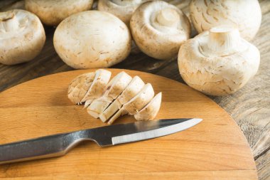 Champignon mantar ve bıçakla kesme tahtası.