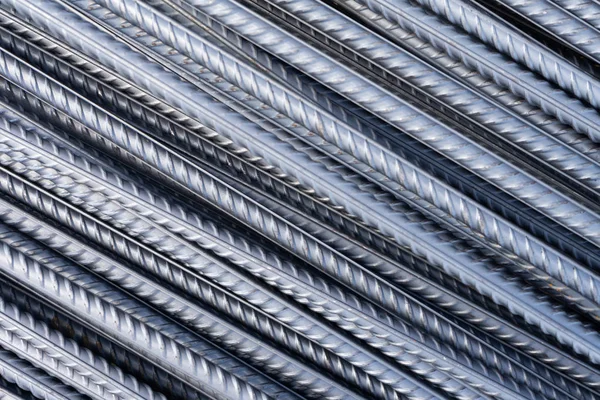 Stack of heavy metal reinforcement bars with periodic profile texture. Close up steel construction armature. Abstract industrial background concept.
