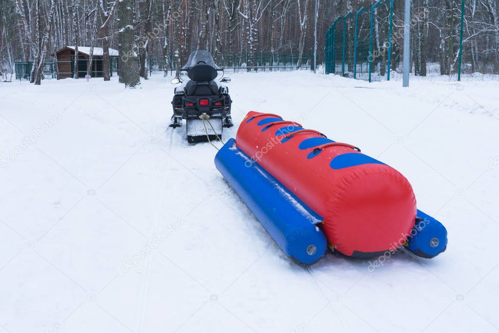 Snowmobile and inflatable sled, winter fun.