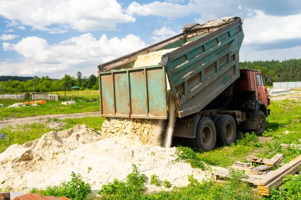 Damperli kamyon kum kaldırır. Kamyon kargo boşaltmış. Kum ve çakıl.