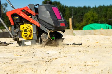 Builder Sıkıştırma silkicileri ile temel kum dökme beton için mühürler. Kopya pasre