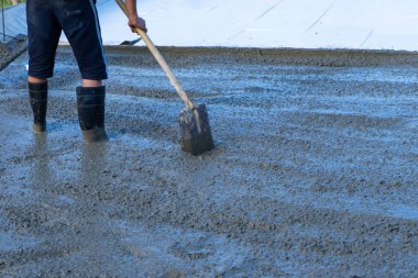 İşçiler Mobil Beton karıştırıcı kullanarak bir konut bina inşaatı için temel dökme. Kopyala Yapıştır