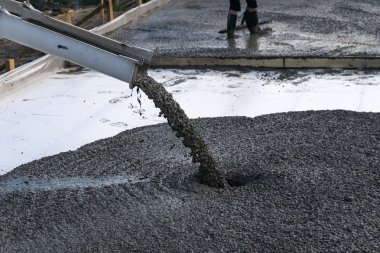 İşçiler Mobil Beton karıştırıcı kullanarak bir konut bina inşaatı için temel dökme. Kopyala Yapıştır