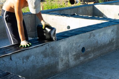 İşçiler Vakfın bir ahşap ev yapımı için su taşırlar. Kopyala Yapıştır.