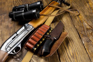 Av tüfeği ve mühimmat ahşap arka plan üzerinde yalan.