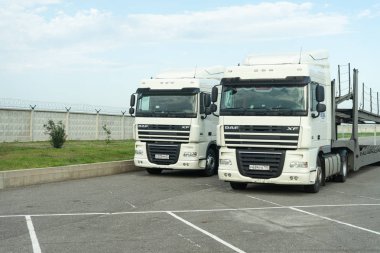 İki kamyon. Araba Bayilik Park edilmiş.