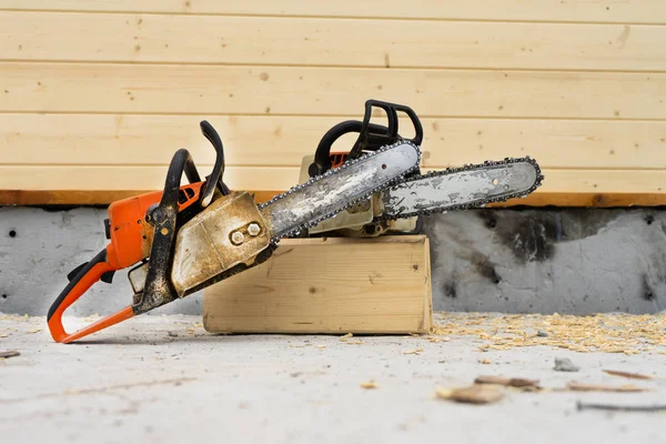 Cuando se construye una casa de madera, dos motosierras un poco . — Foto de Stock