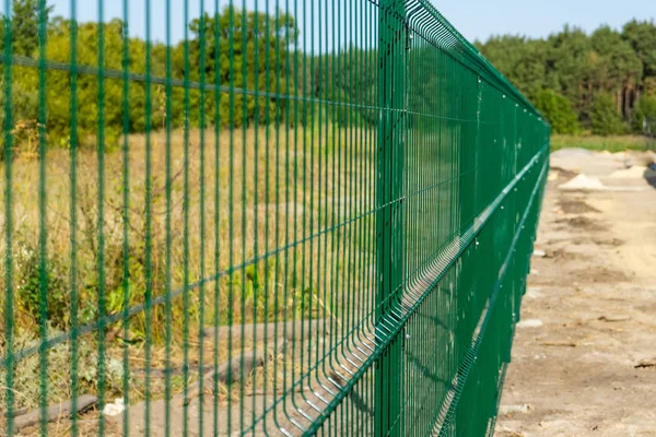 stock image Steel grating fence of field. Metal fence wire with grass in the background