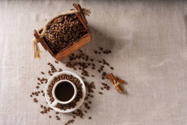 Kahve fincanı ve fasulye eski mutfak masasında.