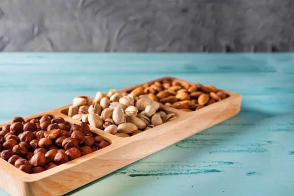 Mavi ahşap masa fındık ile compartmental çanak.