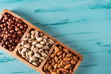 Mavi ahşap masa fındık compartmental tabak. Fındık, badem, Antep fıstığı.