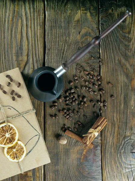 Cezve e chicchi di caffè tostati in scatola su un tavolo rustico, cannella e limone essiccato . — Foto Stock