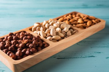 Mavi ahşap masa fındık compartmental tabak. Fındık, badem, Antep fıstığı.