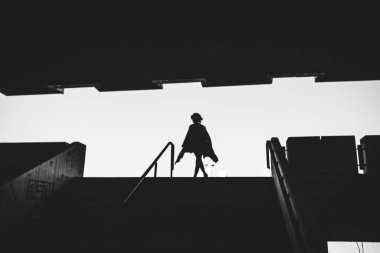 gece karanlığında modern şehir mimarisi karşı duran genç güzel kadın silüeti