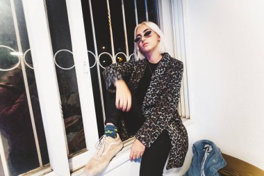 Sarışın hipster genç kadın pencere eşik üzerinde poz
