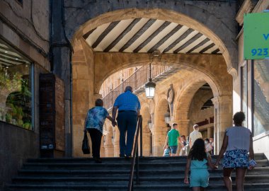 People walking up stone steps to Plaza Mayor in the city of Salamanca, Spain clipart
