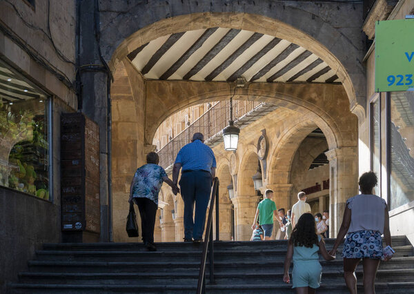 People walking up stone steps to Plaza Mayor in the city of Salamanca, Spain