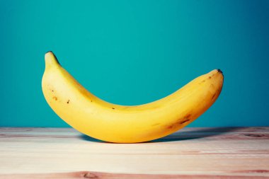 mavi arka plan ile ahşap masada olgun muz