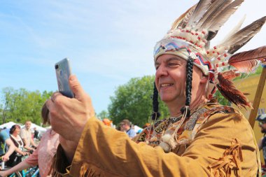 Hint takım elbiseli yaşlı adam akıllı telefondan selfie çekiyor. Beyaz Rusya, Minsk, 18 Mayıs 2019