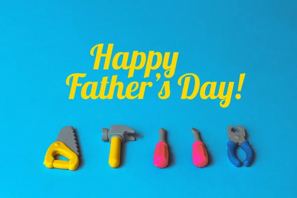 toy tools with happy fathers day lettering on blue background