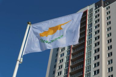 arka planda bina ile mavi gökyüzünde kıbrıs ulusal bayrağı