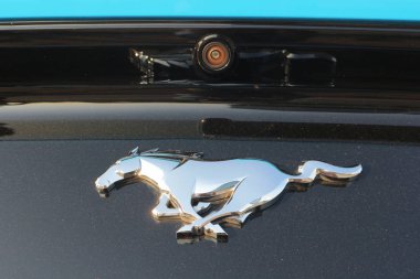 Arabada metal Mustang logosu ve kaputun altındaki kamera. Beyaz Rusya, Minsk, 20 Temmuz 2019.