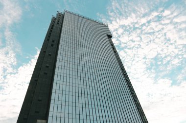 Modern gökdelenin alt görünümü. Gökyüzüne karşı çok katlı ofis binası. Beyaz Rusya, Minsk, 1 Temmuz 2019.