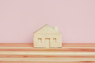 pembe arka plan üzerinde küçük ahşap ev