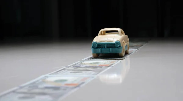 Bir oyuncak araba masanın üzerinde duruyor ve bir dolar ediyor..