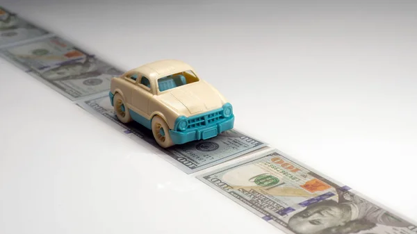 Dolarlık banknotları olan oyuncak araba. seyahat kavramı.