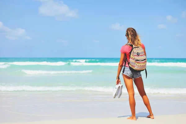 Junge Frau im Sommerkleid steht am blauen Meer — Stockfoto
