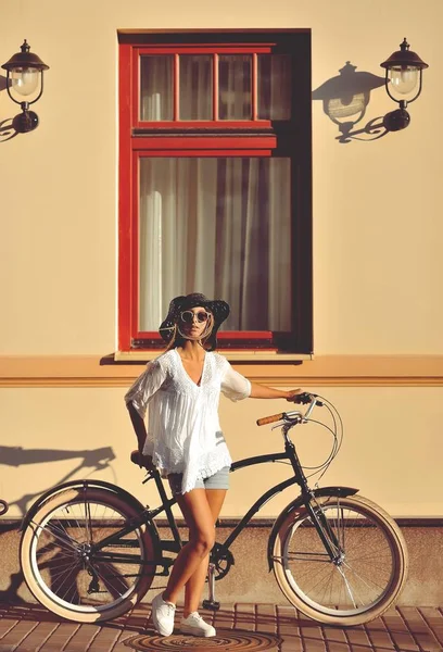 彼女は古い自転車の近くの美しいブロンドの地位。屋外ファッションの肖像画 — ストック写真