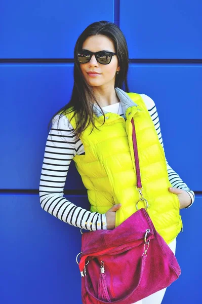 Stylish beautiful girl standing near blue wall — Stock Photo, Image