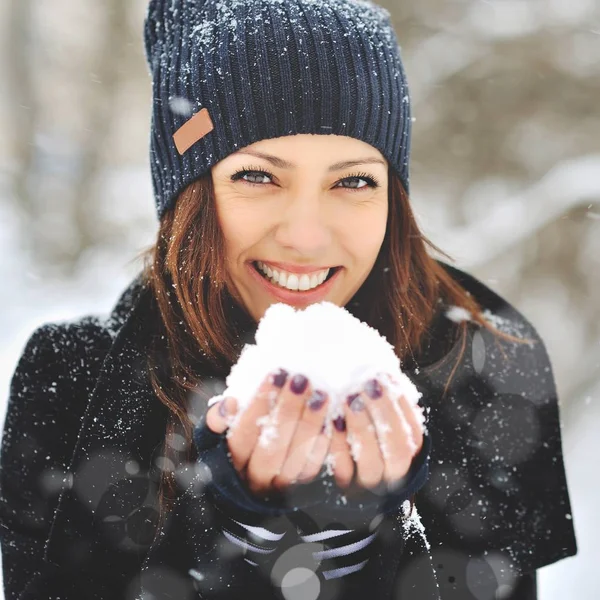 Flicka leker med snö i parken — Stockfoto