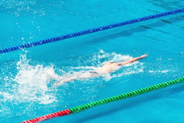 Yüzme havuzunda genç yüzücü. Sağlık ve fitness yaşam tarzı konsepti ile atlet. Yaz güneşli gün.