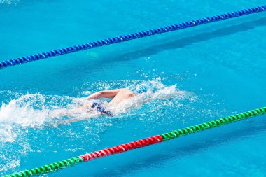 Yüzme havuzunda genç yüzücü. Sağlık ve fitness yaşam tarzı konsepti ile atlet. Yaz güneşli gün.