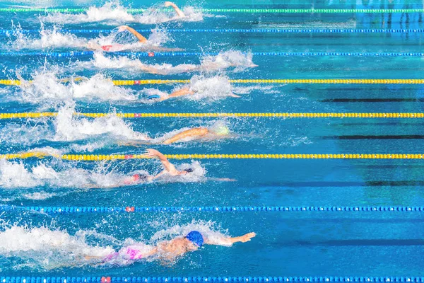 Fiatal úszók verseny alatt kültéri medencében. Egészség és fitness életmód fogalma a gyerekek. — Stock Fotó