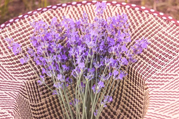 麦わら帽子のラベンダーの花の束。ロマンチックな夏のコンセプトです。アロマセラピー. — ストック写真