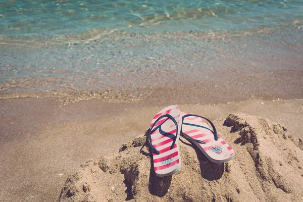 Bunte Flipflop-Paar am Strand des Meeres. Konzept des Leerstandes. — Stockfoto