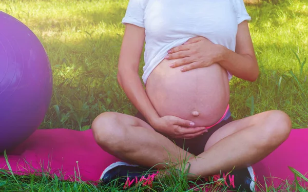 Zdravá těhotná žena cvičí jóga v přírodě venku. Budoucí maminka dělá protahovací cvičení. Prenatální jóga a Fitness. — Stock fotografie