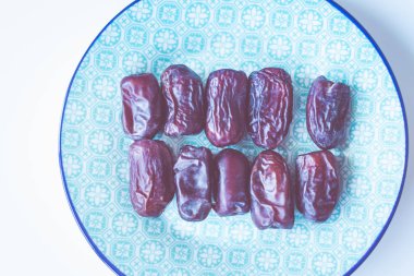 Mavi Arap tarzı plaka üzerinde tatlı İran tarihleri. Organik ürün Asya ve Orta Doğu. Mineral ve vitamin kaynağı. Çiğ vegan Vejetaryen Sağlıklı gıda kavramı.