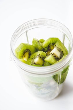 Beyaz arka plan üzerinde bir blender ve taze kivi meyve Düz yatıyordu, smoothies, detoks, sağlıklı temiz beslenme hazırlanıyor. Yaz içkisi.