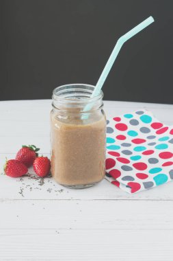 Bebek ıspanak, taze çilek ve chia beyaz ahşap bir masa üzerinde çilek yüzlü. Superfoods, detoks, diyet, sağlık, vejetaryen gıda kavramı.