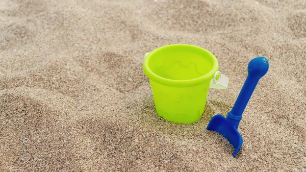 Jouets pour enfants en plastique dans le sable. Concept de vacances en famille. Vue de dessus. Espace pour le texte . — Photo