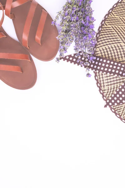 Composition de mode d'été. Bouquet de lavande violette, chapeau de paille d'été pour femmes et sandales en cuir isolées sur vue de dessus blanche. Pose plate, espace de copie. Accessoires femme d'en haut. Concept de vacances . — Photo