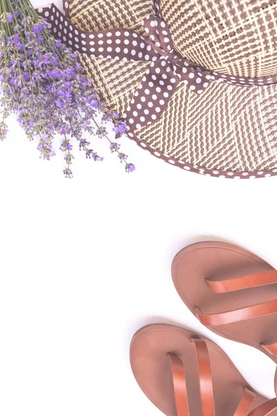 Composition de mode d'été. Bouquet de lavande violette, chapeau de paille d'été pour femmes et sandales en cuir isolées sur vue de dessus blanche. Pose plate, espace de copie. Accessoires femme d'en haut. Concept de vacances . — Photo